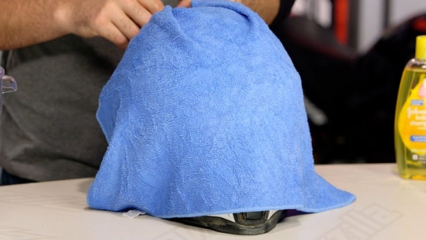 βάλτε μια βρεγμένη πετσέτα πάνω στο κράνος για να μαλακώσει βρωμιά και να φύγει ευκολότερα